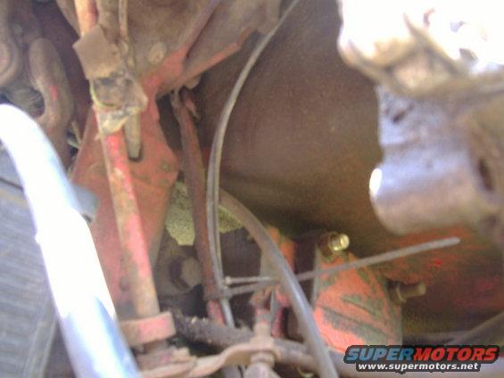 close-up of rusty red metal parts and hoses under a vehicle