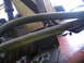 1988 Ford Bronco - Close-up view of engine parts, including metal tubes and a small emblem.