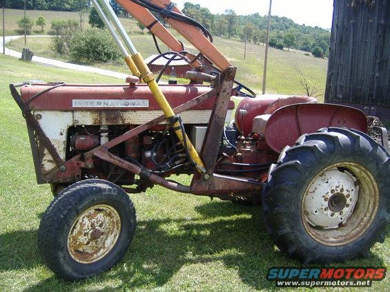 Red tractor with loader, side view. "INTERNATIONAL" visible on hood