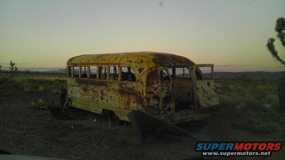 Yellow school bus in desert landscape at dusk