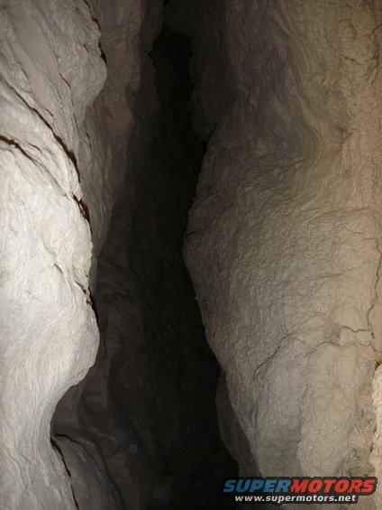Cave interior with rough rock walls and a dark opening