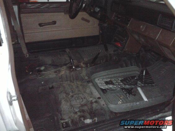 Interior of a 1985 Toyota 4Runner with carpet removed, showing floor and dashboard