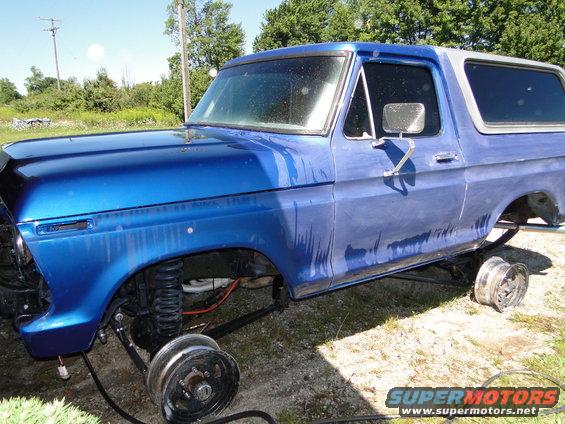 Blue 1978 Ford Bronco, side view, missing wheels, with a white hardtop