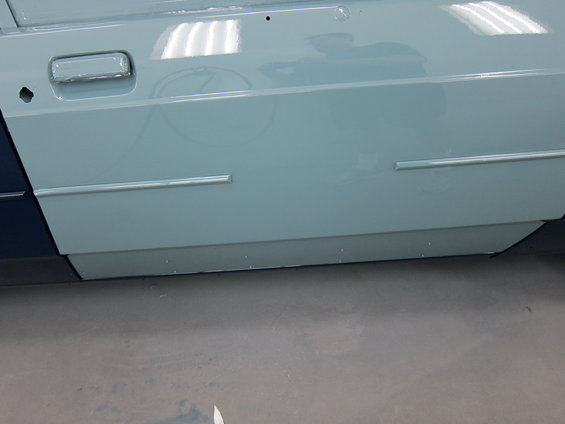 Light blue car door with chrome trim and a dark blue lower section