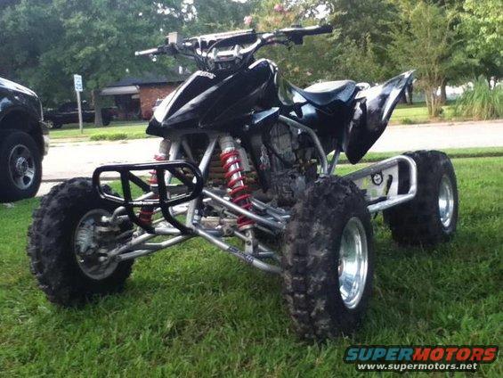 Black 2004 Honda TRX 400 EX ATV parked on grass, front-left view. Another vehicle is partially visible to the left