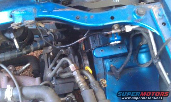 close-up of blue painted engine bay with hoses and wires