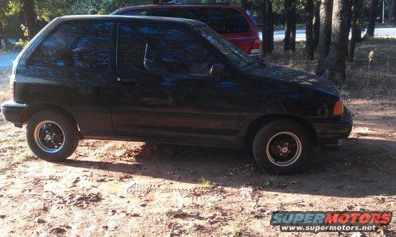Black hatchback parked outdoors, red SUV behind it