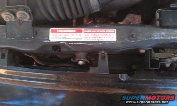 engine bay with red warning labels about fan
