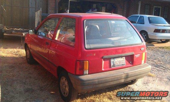 Red 1991 Ford Festiva parked next to a silver sedan