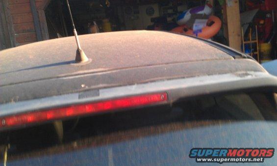 Rear spoiler with third brake light on a dusty car roof
