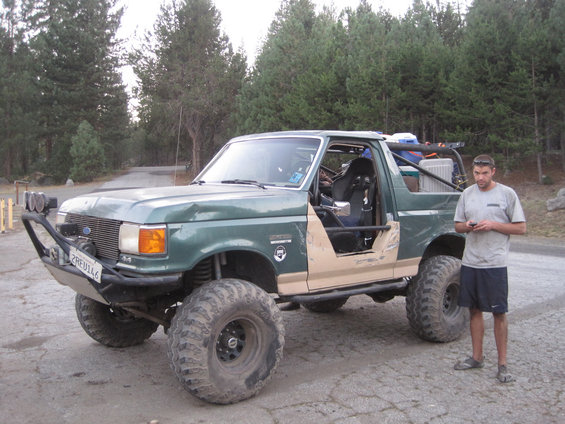 Green Ford Bronco with tan lower body panels, off-road tires, and a custom bumper