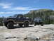 1986 Ford Bronco - Two Ford Broncos are parked on a rocky surface in a mountainous area.