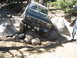 1986 Ford Bronco - This Ford Bronco is shown off-roading through a challenging rocky path in a wooded area.