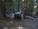 1986 Ford Bronco - A person walks alongside a vintage pickup truck navigating a rocky, wooded trail.
