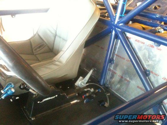 Vehicle interior with bucket seat, roll cage, and floor shifter