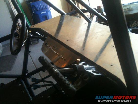 Custom buggy interior with roll cage, steering wheel, and metal floor panel