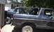 1979 Ford Bronco - Two Ford Broncos are parked side-by-side in a driveway, one appears to be undergoing modification.