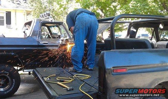 Black Ford Bronco being worked on, sparks flying from the side panel