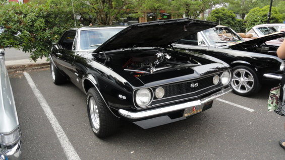 Black Chevrolet Camaro SS with hood open, showing engine. Chrome trim and SS badges visible