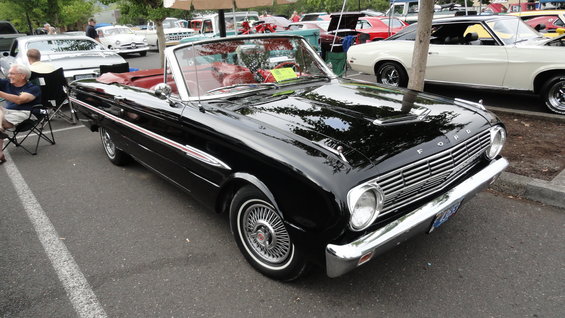 Black 1964 Ford Fairlane convertible parked next to other cars at a car show
