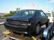 1987 Ford Mustang - A black 1987 Ford Mustang coupe is seen on a trailer, viewed from the rear.