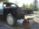 1987 Ford Mustang - Front view of a 1987 Ford Mustang chassis being transported on a flatbed trailer.