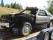 1987 Ford Mustang - This 1987 Ford Mustang is being transported on a trailer, appearing to be a project car with its front end disassembled.