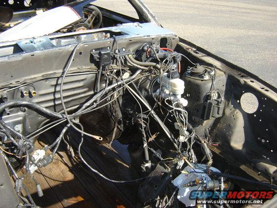 Engine bay of a 1987 Ford Mustang with exposed wiring and components