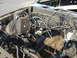 1987 Ford Mustang - The engine bay of a 1987 Ford Mustang shows exposed wiring and a wooden floor, suggesting a custom build or restoration project.