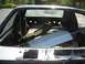 1987 Ford Mustang - The interior of a car has been stripped down, with various parts stored in the rear cargo area.