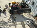 1987 Ford Mustang - A disassembled car dashboard and wiring harness lie on a concrete surface, with lawnmowers and tires nearby.