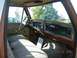 1979 Ford F-150 - The interior of a 1979 Ford F-150 shows a brown dashboard and patterned bench seat.