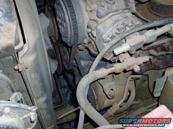 Close-up of engine bay parts, including belts and hoses