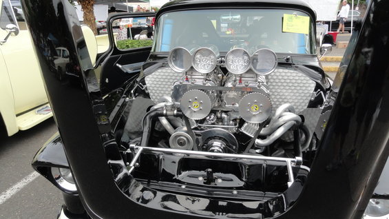 Black hot rod engine with dual carburetors and chrome details, hood open