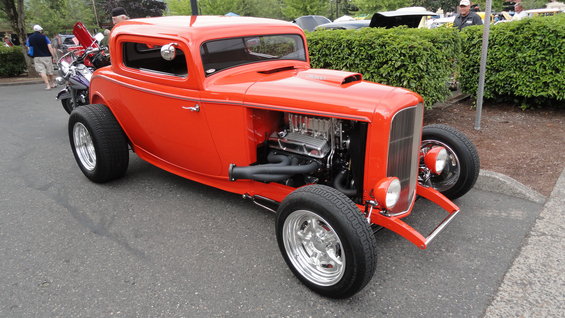 Orange hot rod coupe, exposed engine, chrome wheels, wide tires