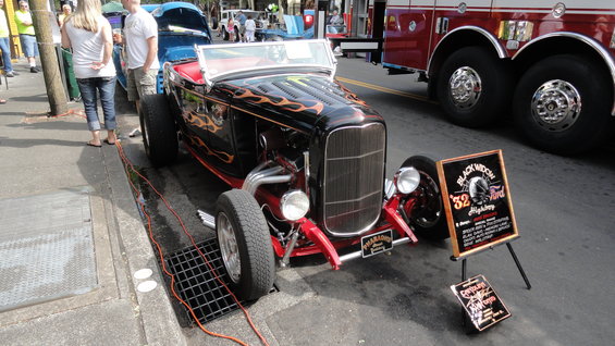 Black hot rod with flames, has a sign that says 'Black Widow '32 Ford Highway'