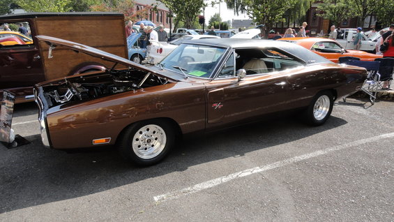 Brown 1969 Dodge Charger with hood open, showing chrome engine parts and a black vinyl roof