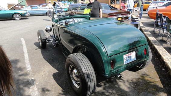 Green hot rod roadster with exposed front suspension and rear-mounted spare tire. Washington license plate 5440 visible