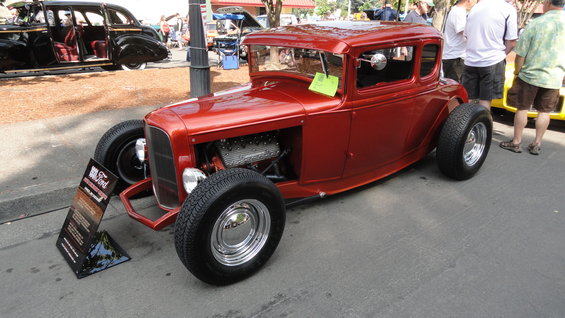 Red hot rod coupe with exposed engine and chrome wheels