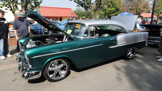Green and silver 1955 Chevrolet Bel Air with hood open, parked next to other cars
