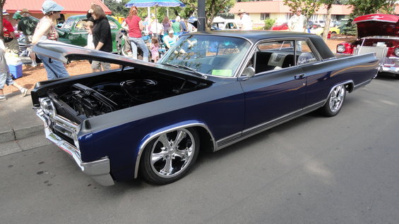 Two-tone blue and gray 1964 Ford Fairlane coupe with hood open, chrome wheels, and custom lowered suspension