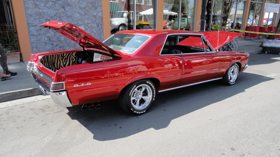 Red 1965 Pontiac GTO with hoods open, zebra-print trunk lining