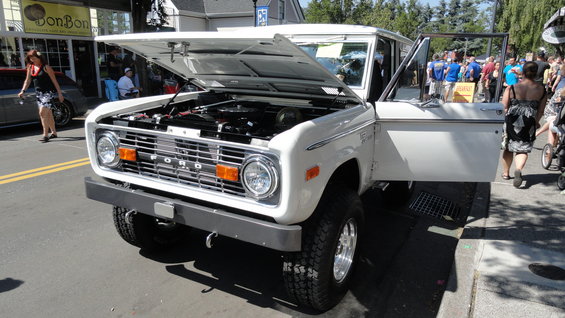 White Ford Bronco, front view, hood and door open. Visible 'FORD' grille