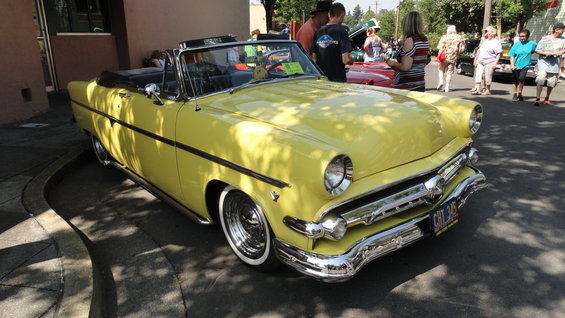 Yellow 1954 convertible with chrome grille and whitewall tires