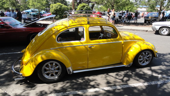Yellow Volkswagen Beetle with a roof rack, chrome wheels, and lowered suspension
