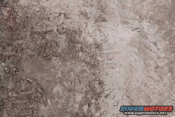 Dirt ground with tire tracks and debris. Supermotors.net logo in the lower right corner