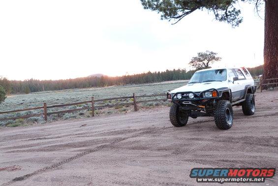 White 1985 Toyota 4Runner with off-road modifications parked on a dirt road