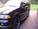 1996 Ford Bronco - This black SUV features chrome trim and custom wheels, seen from a three-quarter front view.