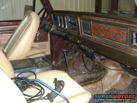 1979 Ford Bronco interior showing woodgrain dashboard trim, tan seats, and floor shifter