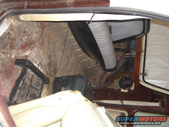 Interior rear cargo area with worn flooring and seats